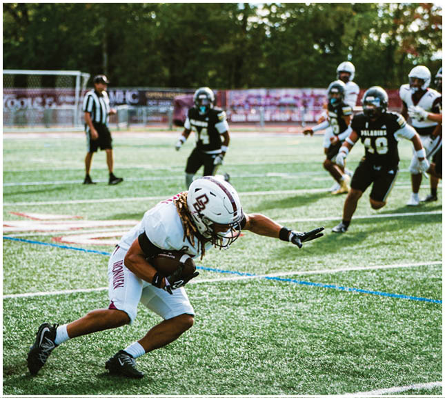 A football player wearing a blue and red jersey. Description generated by AI