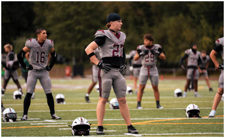 A football player wearing a blue and red jersey. Description generated by AI