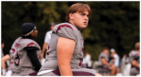 A football player wearing a blue and red jersey. Description generated by AI