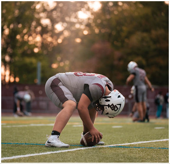 A football player wearing a blue and red jersey. Description generated by AI
