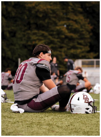 A football player wearing a blue and red jersey. Description generated by AI