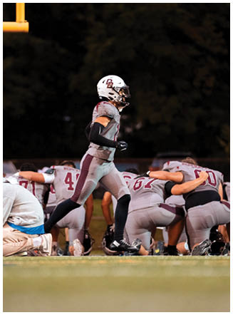 A football player wearing a blue and red jersey. Description generated by AI