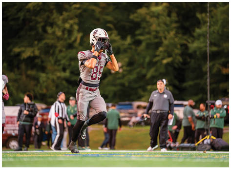 A football player wearing a blue and red jersey. Description generated by AI