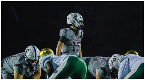 A football player wearing a blue and red jersey. Description generated by AI