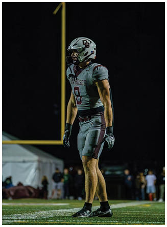 A football player wearing a blue and red jersey. Description generated by AI