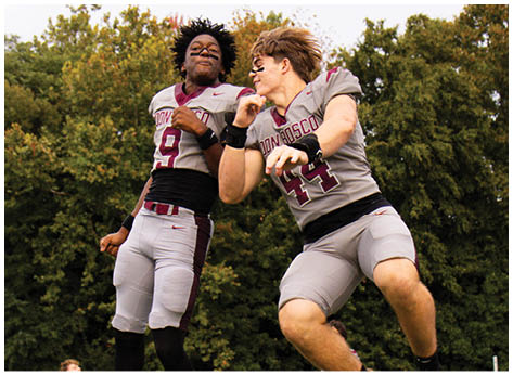 A football player wearing a blue and red jersey. Description generated by AI