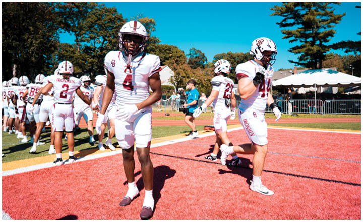 A football player wearing a blue and red jersey. Description generated by AI