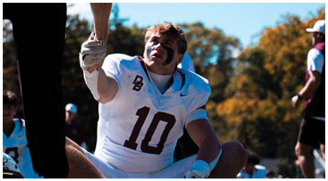 A football player wearing a blue and red jersey. Description generated by AI