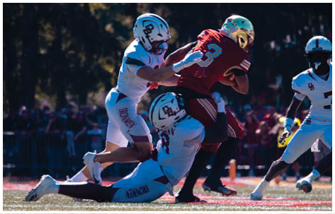 A football player wearing a blue and red jersey. Description generated by AI