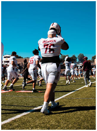 A football player wearing a blue and red jersey. Description generated by AI