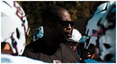 A football player wearing a blue and red jersey. Description generated by AI