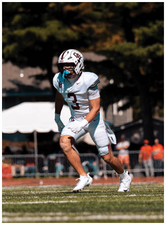 A football player wearing a blue and red jersey. Description generated by AI