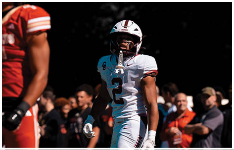 A football player wearing a blue and red jersey. Description generated by AI