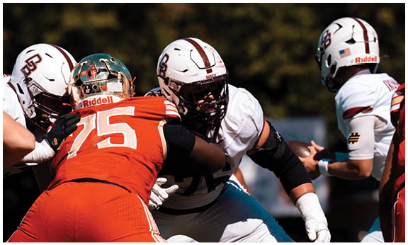 A football player wearing a blue and red jersey. Description generated by AI