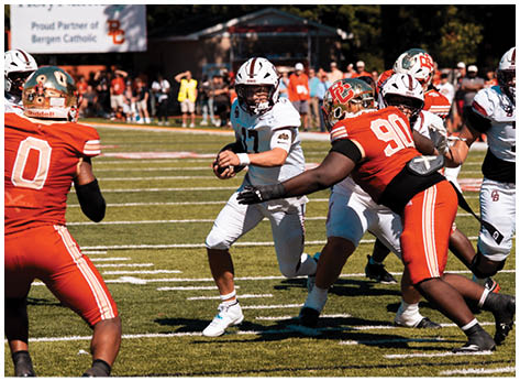 A football player wearing a blue and red jersey. Description generated by AI