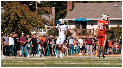 A football player wearing a blue and red jersey. Description generated by AI