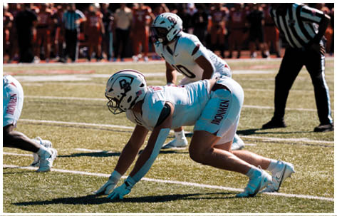 A football player wearing a blue and red jersey. Description generated by AI