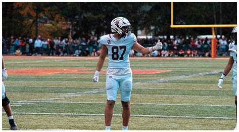 A football player wearing a blue and red jersey. Description generated by AI