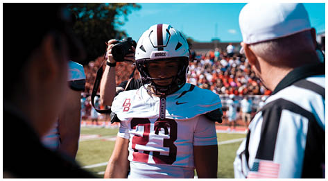 A football player wearing a blue and red jersey. Description generated by AI