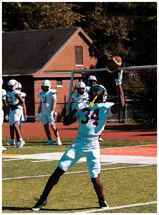 A football player wearing a blue and red jersey. Description generated by AI