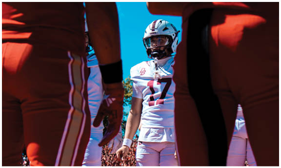 A football player wearing a blue and red jersey. Description generated by AI