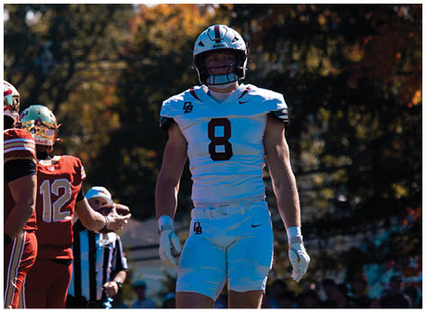 A football player wearing a blue and red jersey. Description generated by AI