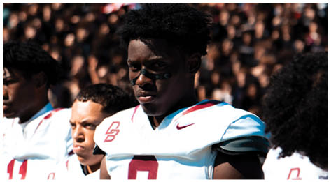 A football player wearing a blue and red jersey. Description generated by AI