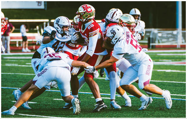 A football player wearing a blue and red jersey. Description generated by AI