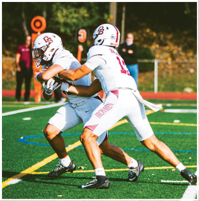 A football player wearing a blue and red jersey. Description generated by AI