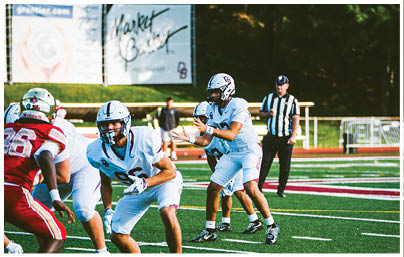 A football player wearing a blue and red jersey. Description generated by AI