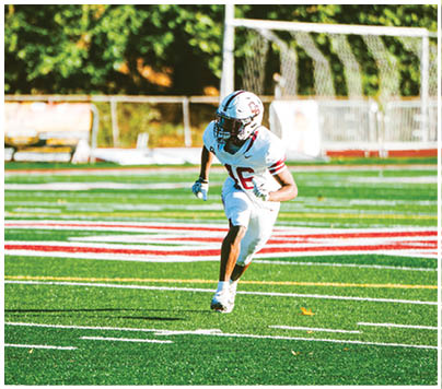 A football player wearing a blue and red jersey. Description generated by AI