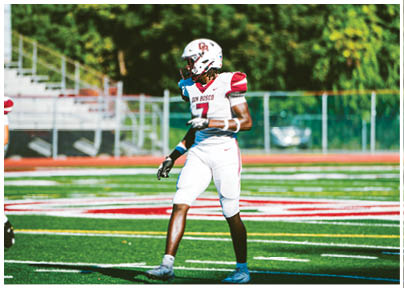 A football player wearing a blue and red jersey. Description generated by AI