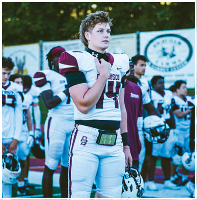 A football player wearing a blue and red jersey. Description generated by AI