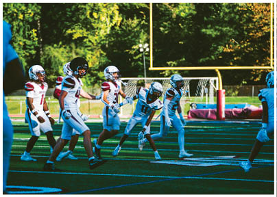 A football player wearing a blue and red jersey. Description generated by AI