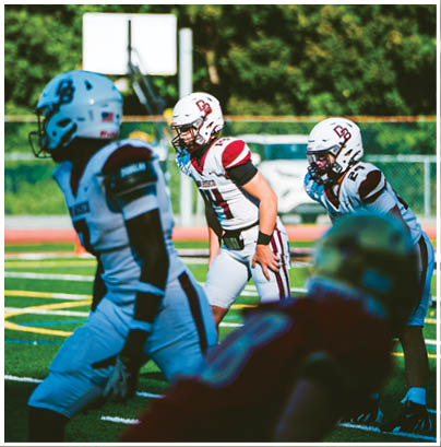 A football player wearing a blue and red jersey. Description generated by AI