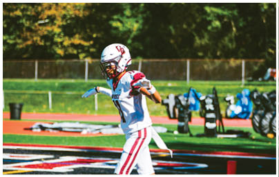 A football player wearing a blue and red jersey. Description generated by AI