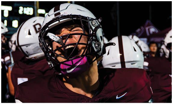 A football player wearing a blue and red jersey. Description generated by AI