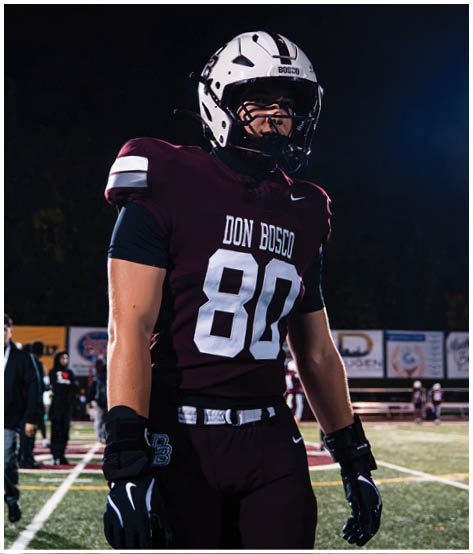 A football player wearing a blue and red jersey. Description generated by AI