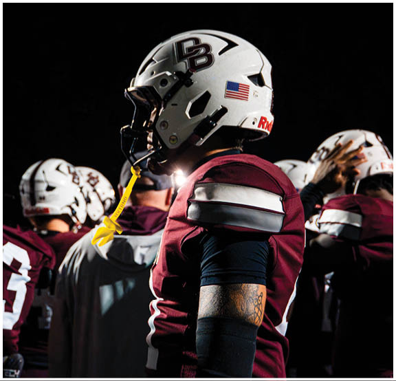 A football player wearing a blue and red jersey. Description generated by AI