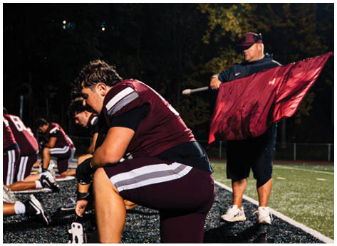 A football player wearing a blue and red jersey. Description generated by AI