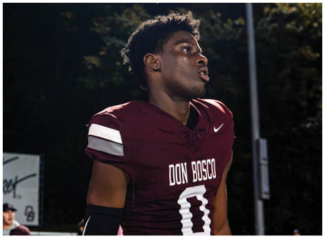 A football player wearing a blue and red jersey. Description generated by AI