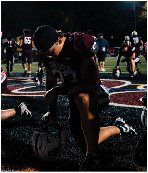 A football player wearing a blue and red jersey. Description generated by AI