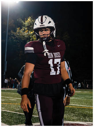 A football player wearing a blue and red jersey. Description generated by AI