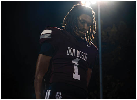 A football player wearing a blue and red jersey. Description generated by AI