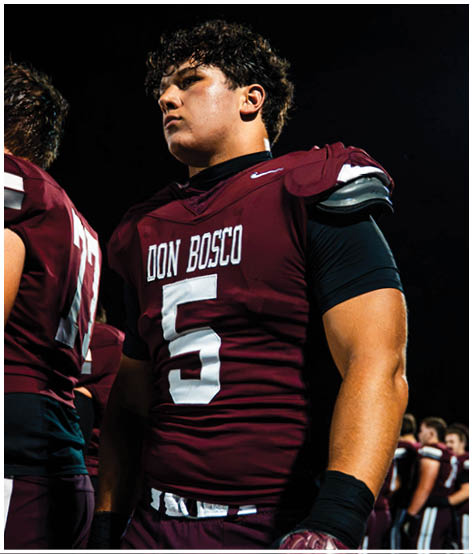A football player wearing a blue and red jersey. Description generated by AI
