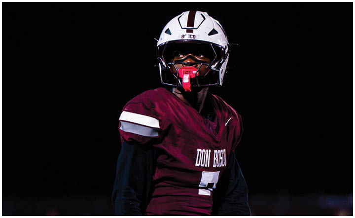 A football player wearing a blue and red jersey. Description generated by AI