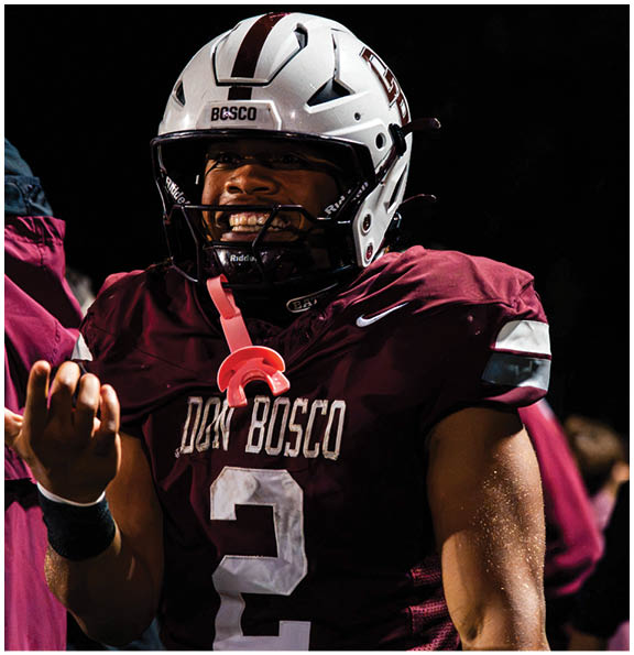 A football player wearing a blue and red jersey. Description generated by AI