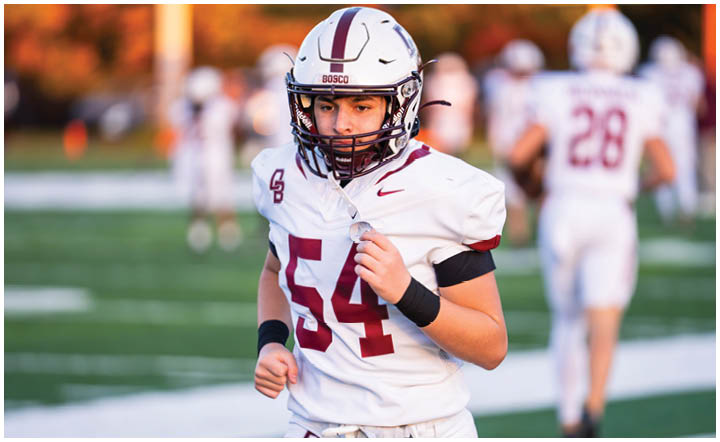 A football player wearing a blue and red jersey. Description generated by AI