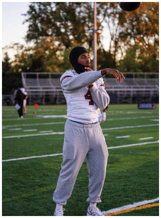 A football player wearing a blue and red jersey. Description generated by AI
