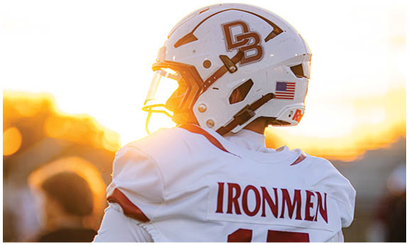 A football player wearing a blue and red jersey. Description generated by AI
